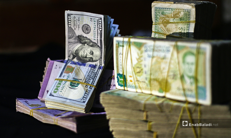 صور تعبيرية لعملة سورية من فئة ألفين و دولار أمريكي في مدينة إدلب - 2 حزيران 2020 (عنب بلدي/ يوسف غريبي)