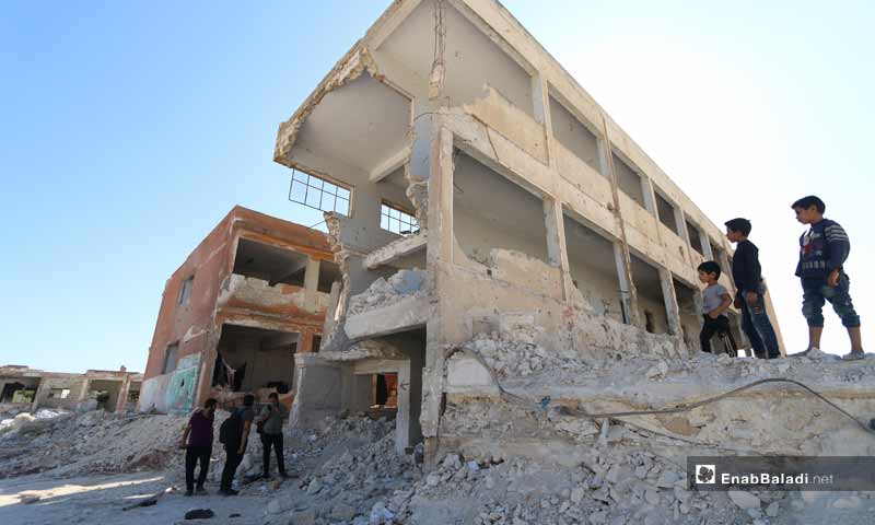 Children looking at their school, destroyed as a result of bombardment in the city of Binnish - 27 September 2019 (Enab Baladi)