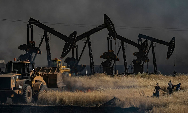 People extinguishing fire near an oil well in an agricultural field, al-Qahtaniyah town in al-Hasakeh governorate- 10 June 2019 (AFP)