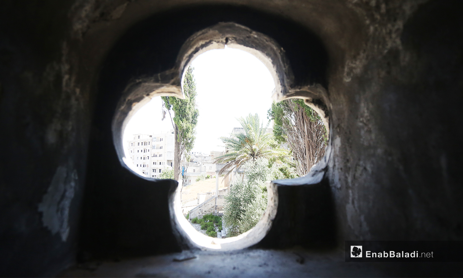 A cross engraved on a wall inside “Mar Georges” Church, which was damaged and burned due to bombardment – July 2020 (Enab Baladi)