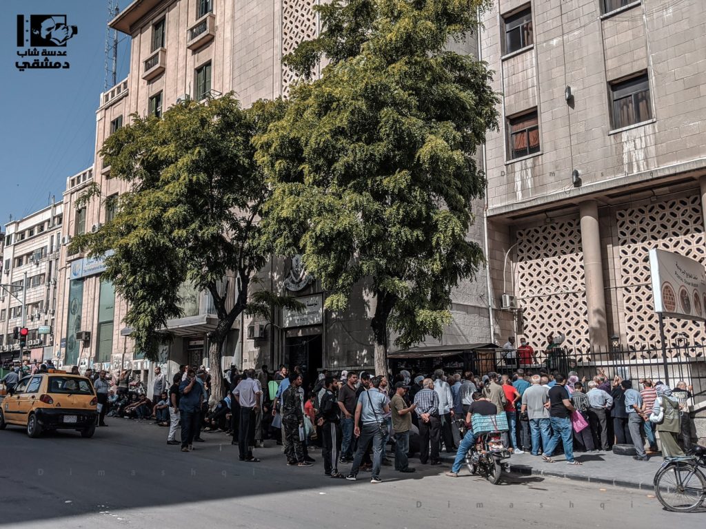 Syrian employees waiting to receive stamps to obtain a grant given to state institutions employees who had been suspended due to the spread of COVID-19 in Damascus - May 2020 (Lens of a young Damascene)