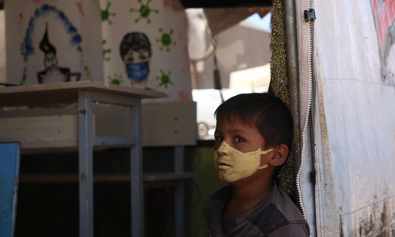 A child with a protective mask against the novel coronavirus painted on his face in the “al-Anwar” displacement camp, west of Maraat Misrin, northwestern Syria- 16 September 2020 (AFP/ Muhammad al-Rifai)